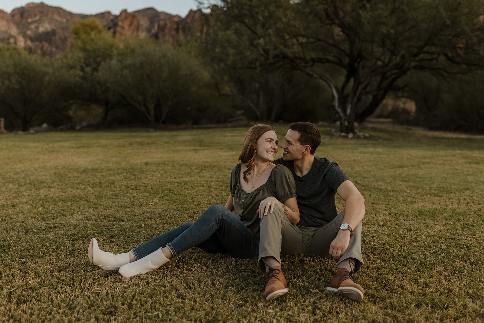couple sitting on the ground looking at each other and smiling at saguaro lake guest ranch Arizona 