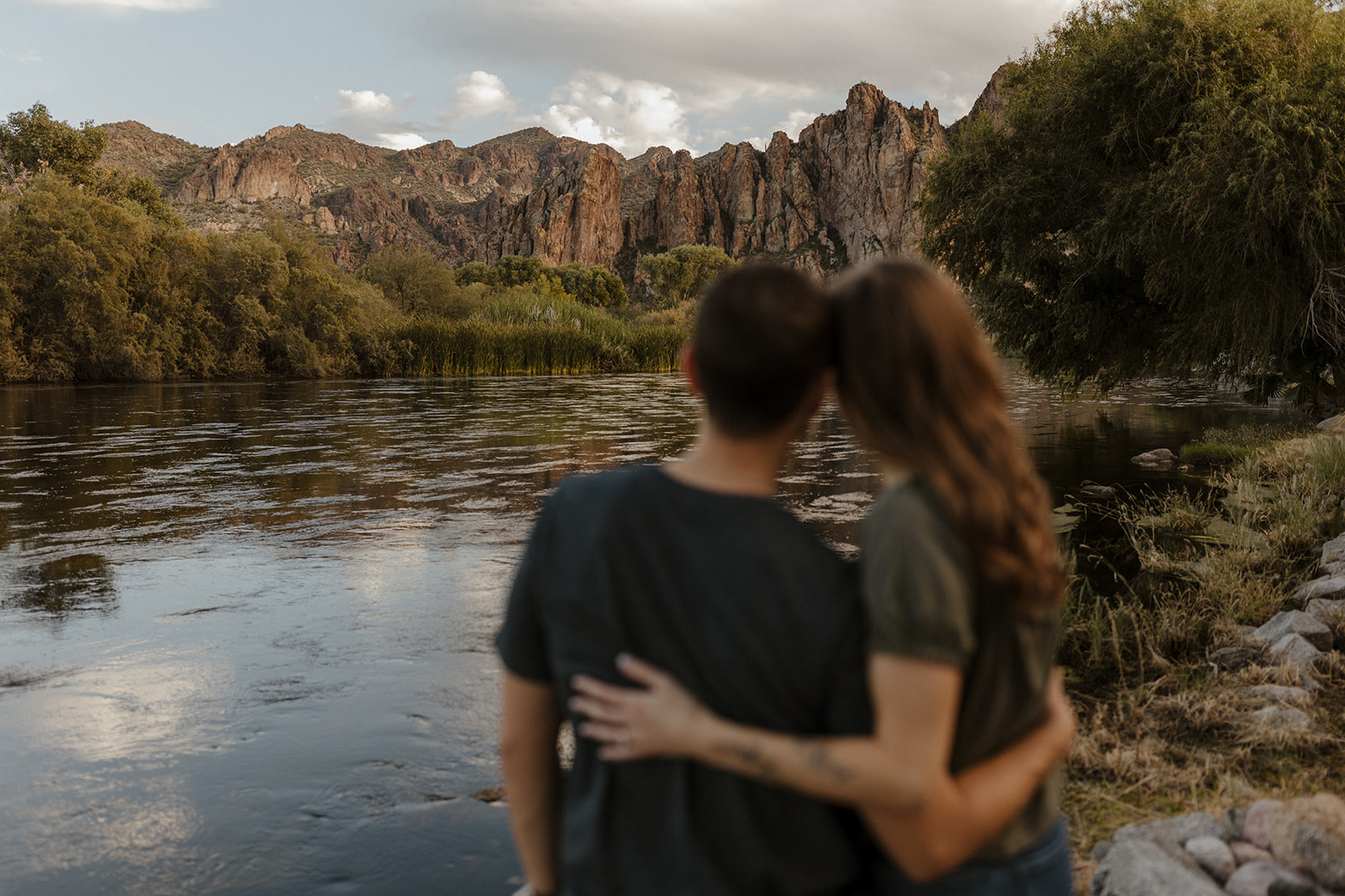 couple blurred out with river and mountain background in focus 