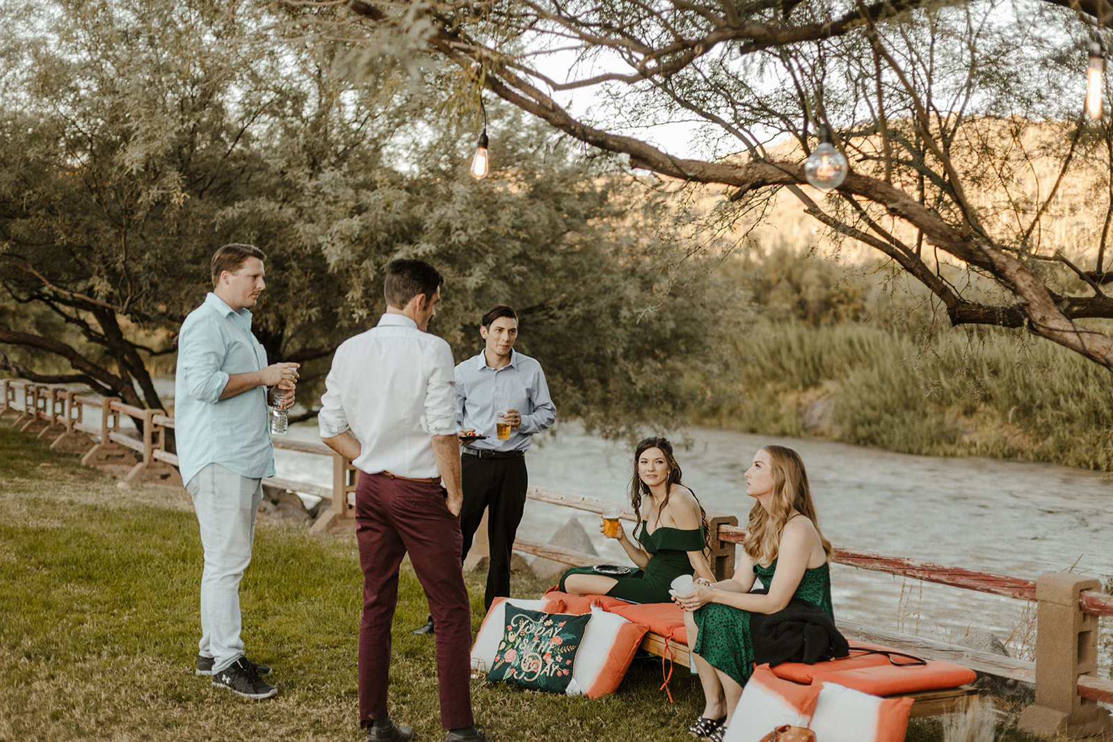guests sitting by the river during cocktail hour at Arizona desert wedding