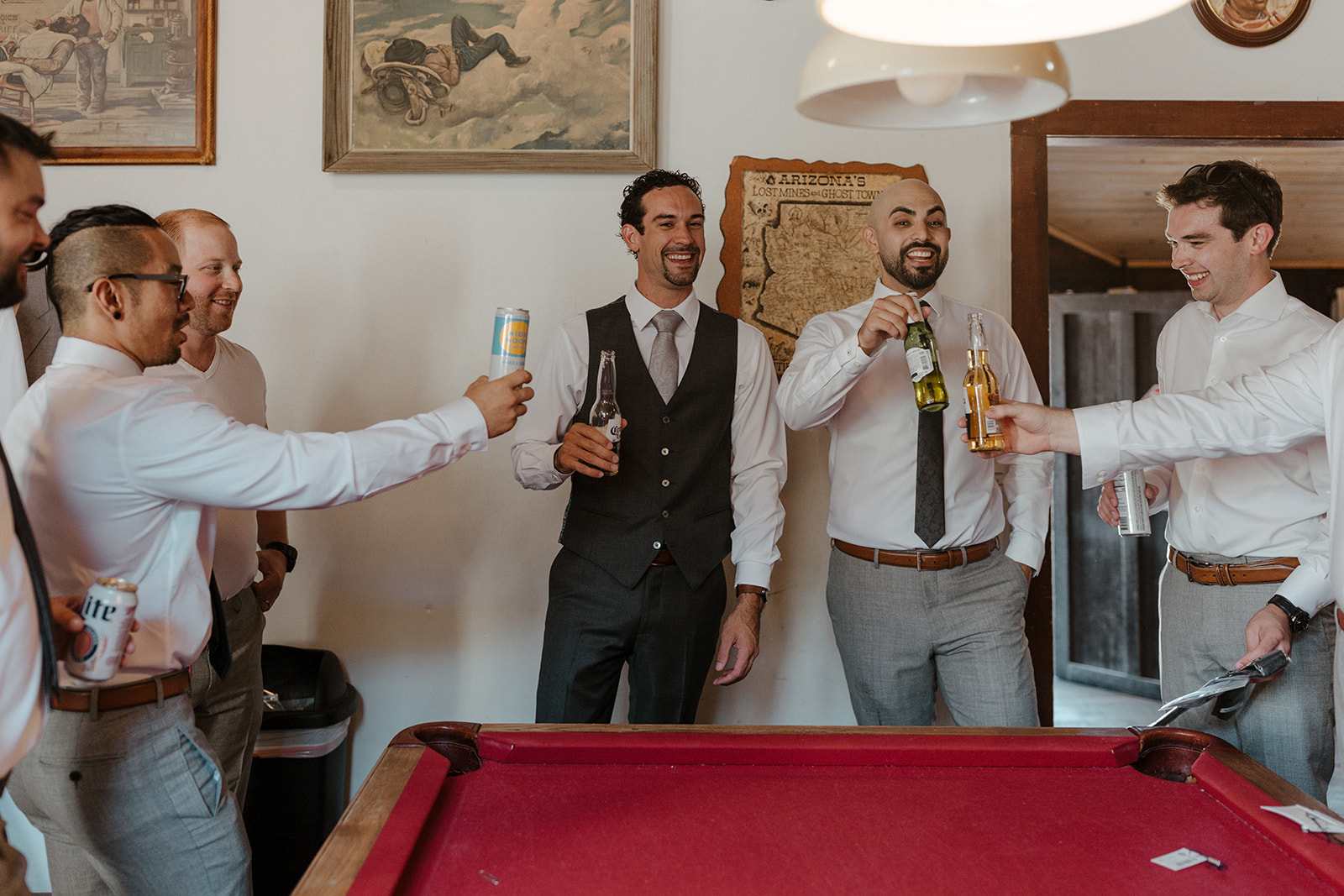 groom and groomsmen sharing beverages while getting ready 