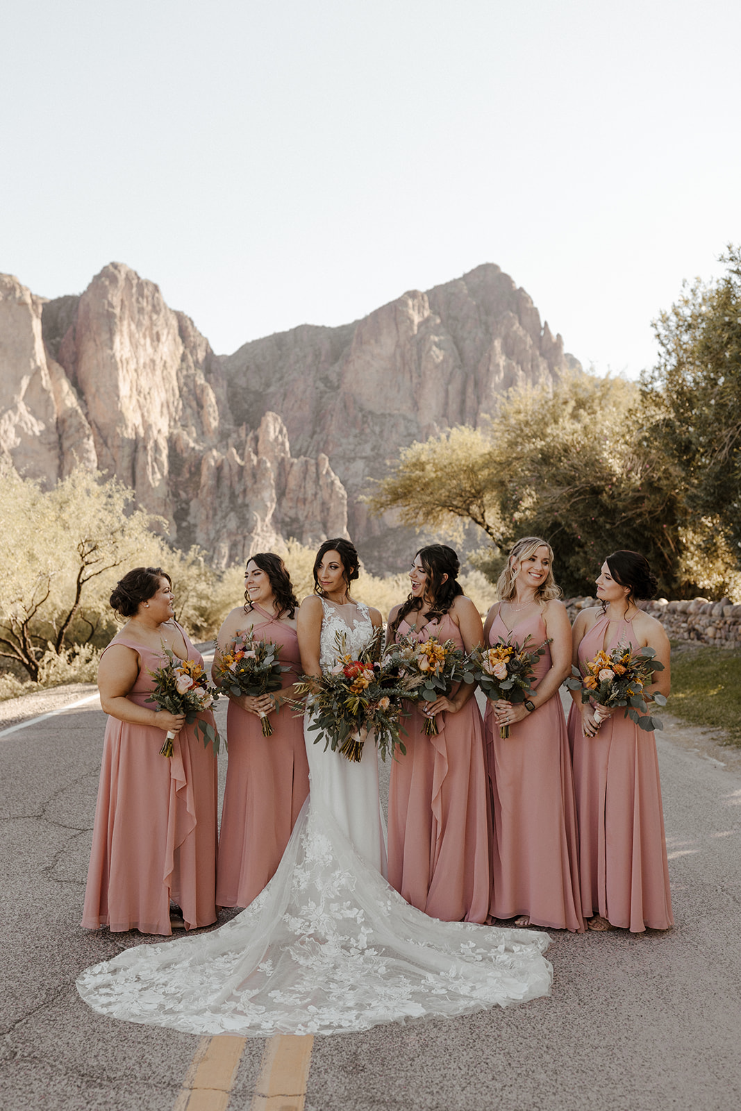 bride and bridesmaids portraits on the road with the mountains behind at Saguaro Lake Guest Ranch Wedding