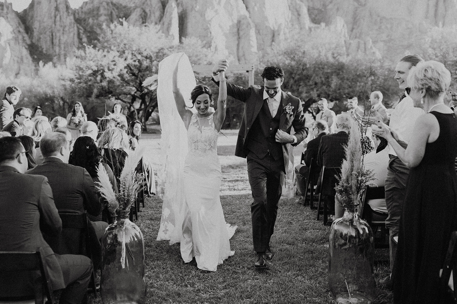 bride and groom walking down the aisle with their hands in the air at Saguaro Lake Guest Ranch Wedding