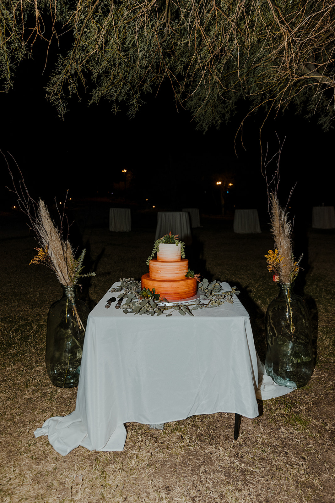 orange wedding cake with boho wedding decorations 