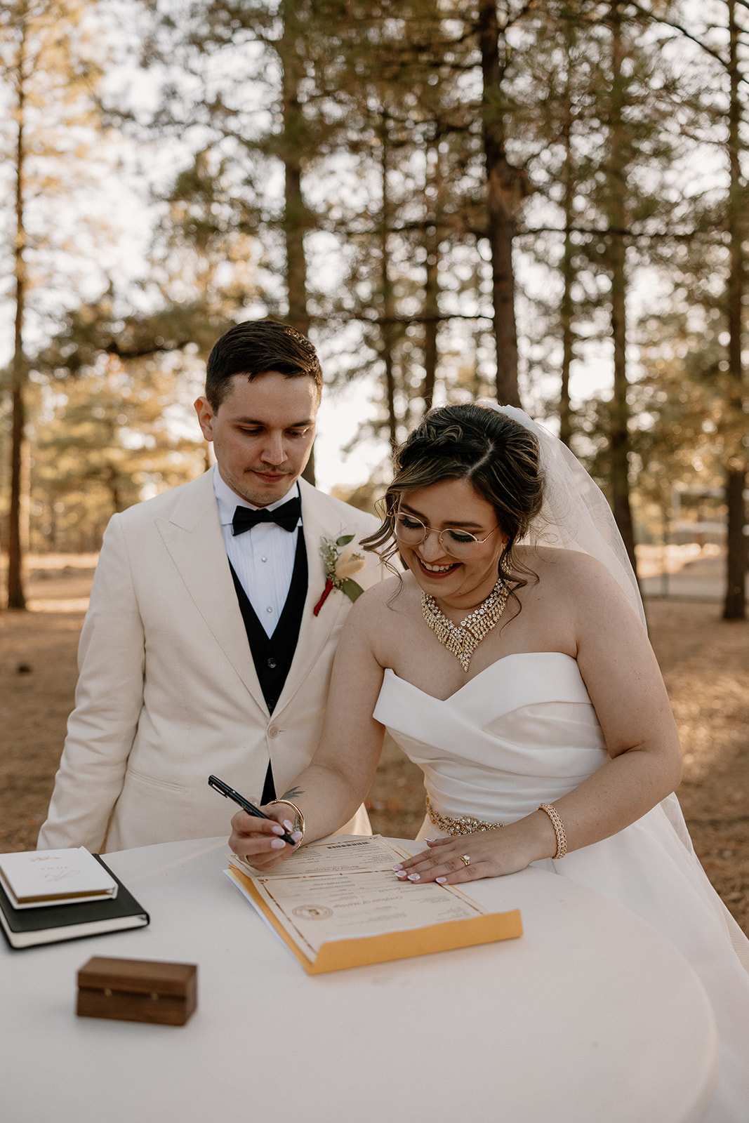 Stunning bride and groom pose together signing their marriage license