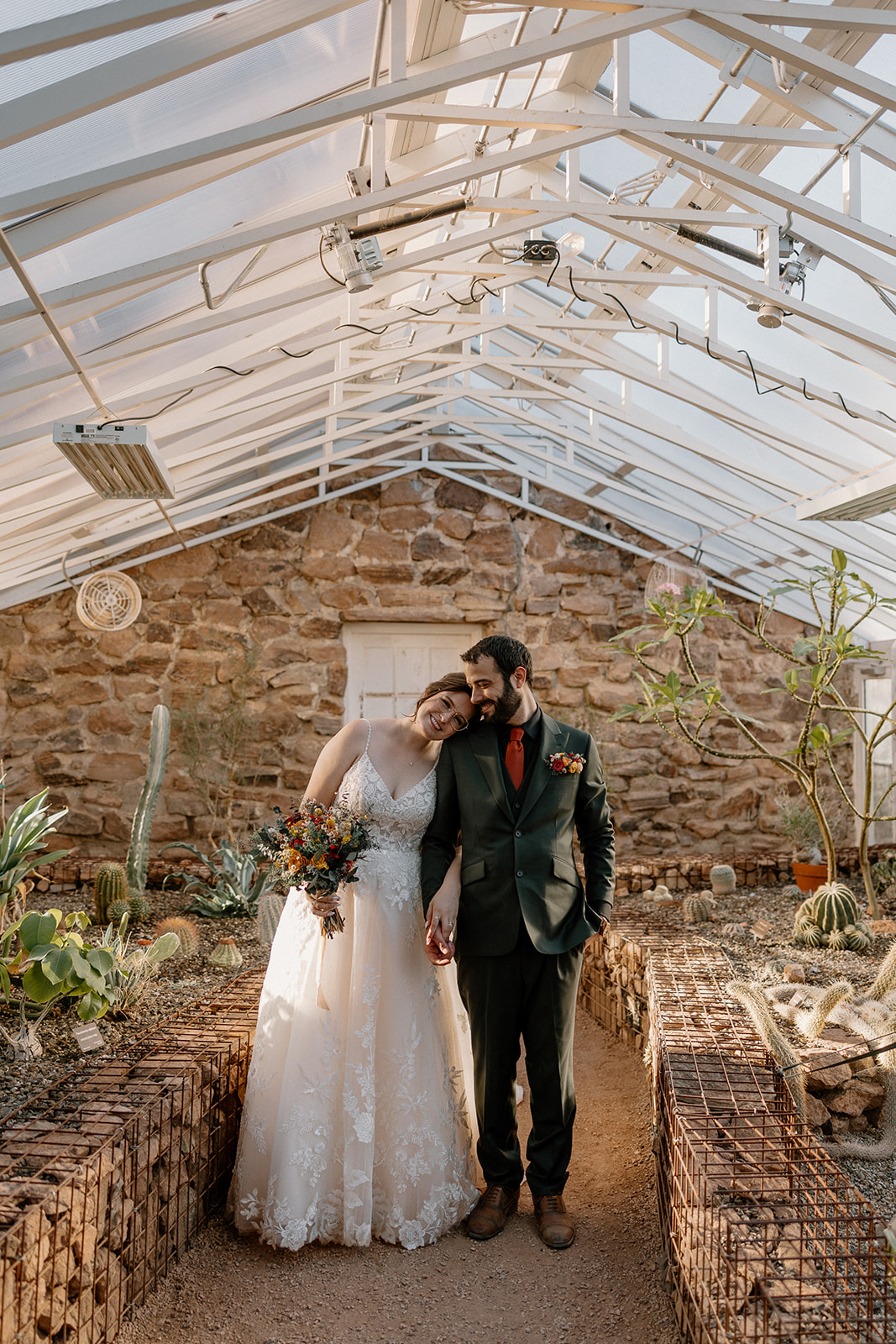 bride and groom posing in greenhouse at boyce thompson arboretum