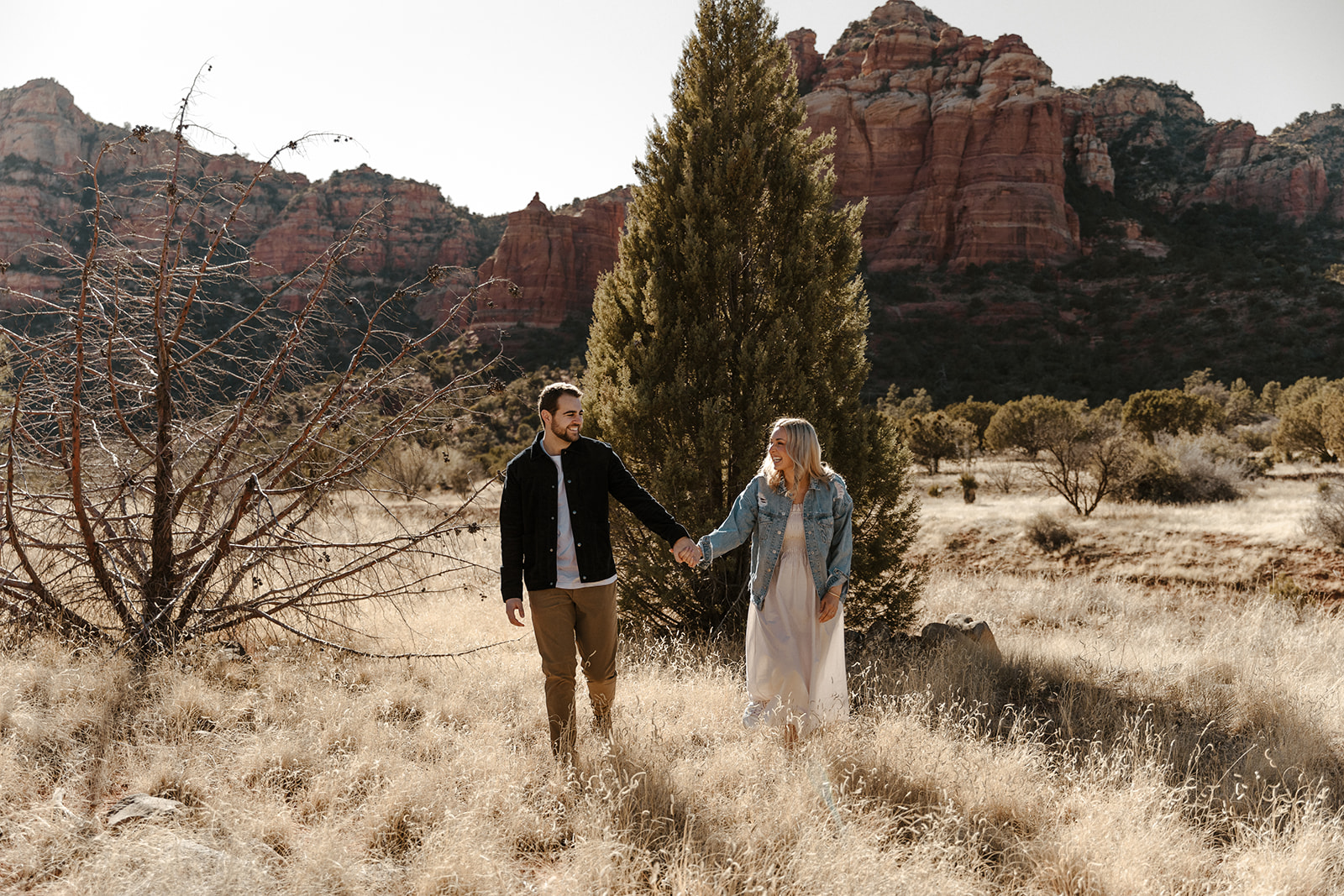 engaged couple laughing and walking together in sedona 