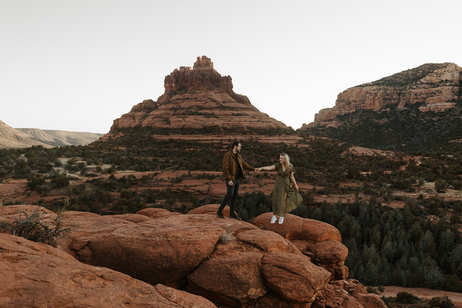 engaged couple holding hands on the red rocks in sedona 
