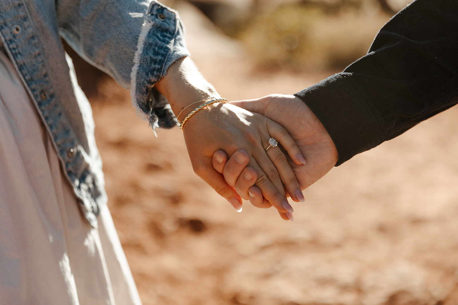 close up of engaged couple holding hands