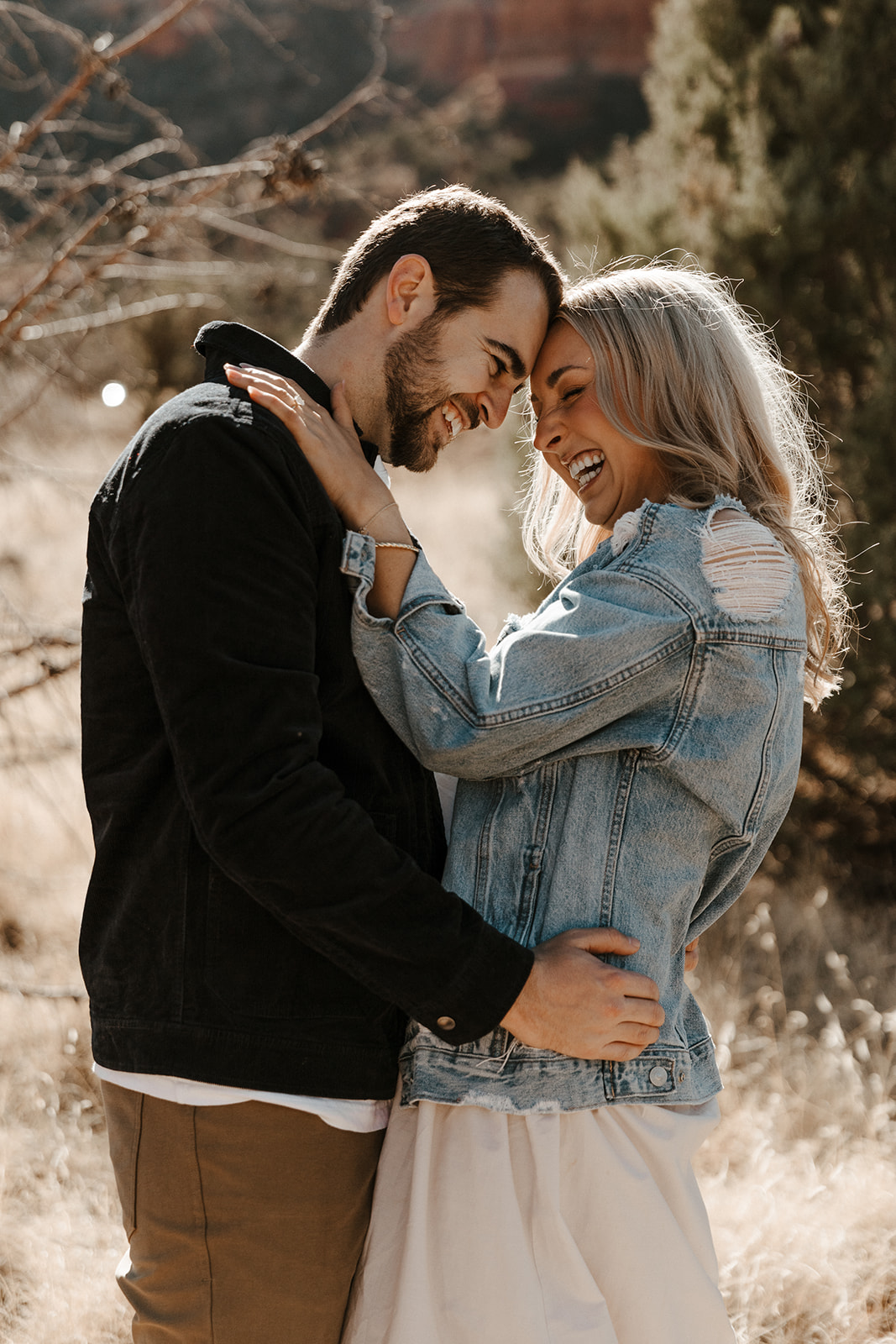 engaged couple laughing and holding each other during sedona engagement photos