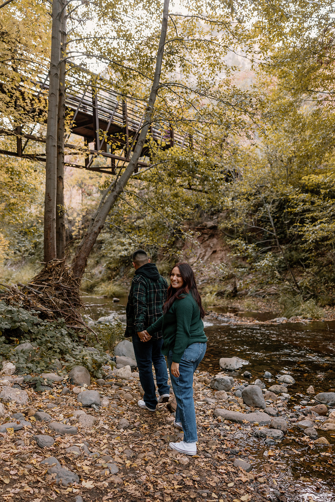 couple walks along the creek during their dreamy Arizona engagement photoshoot