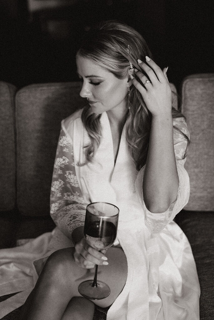 Stunning bride poses with a glass of champagne before her stunning Arizona wedding day 