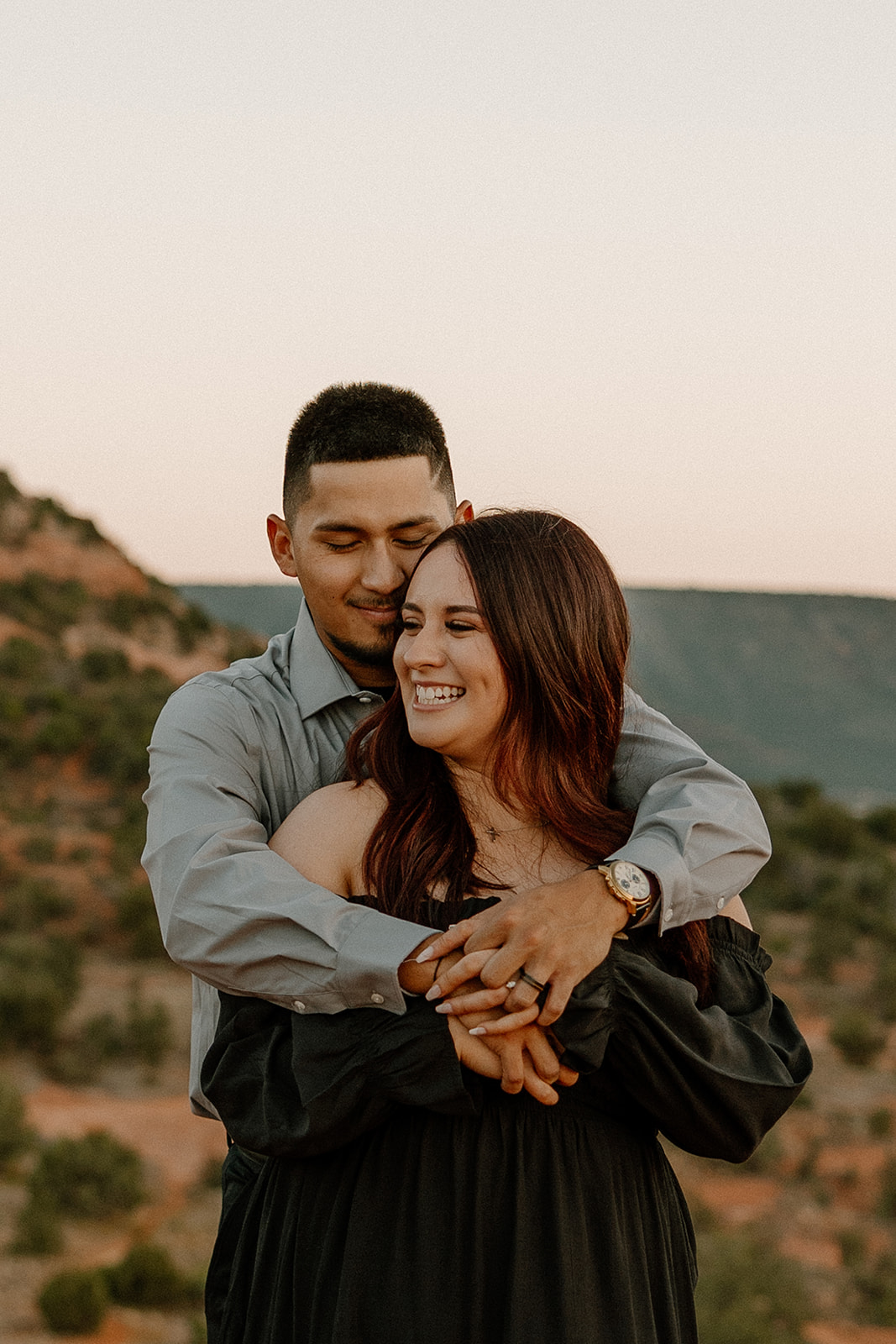 Stunning couple share a hug with the beautiful Arizona nature in the backdrop during their dreamy west fork trail in Sedona Arizona engagement photoshoot 