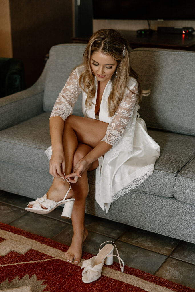 Bride puts her heels on as she finalizes prep for her dreamy Arizona wedding day 