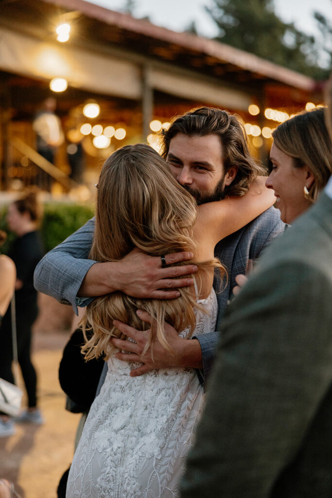 Bride hugs her guests as they enter the stunning Poco Diablo Resort wedding reception!
