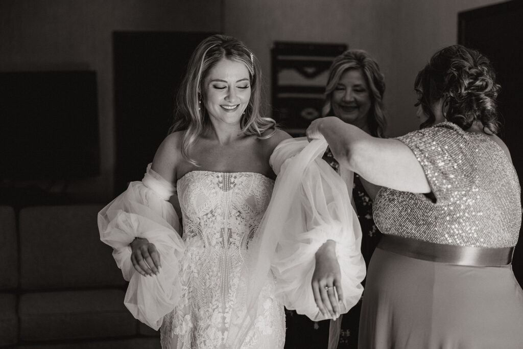 Bride gets help putting her dress on as her Poco Diablo Resort wedding ceremony moves closer!