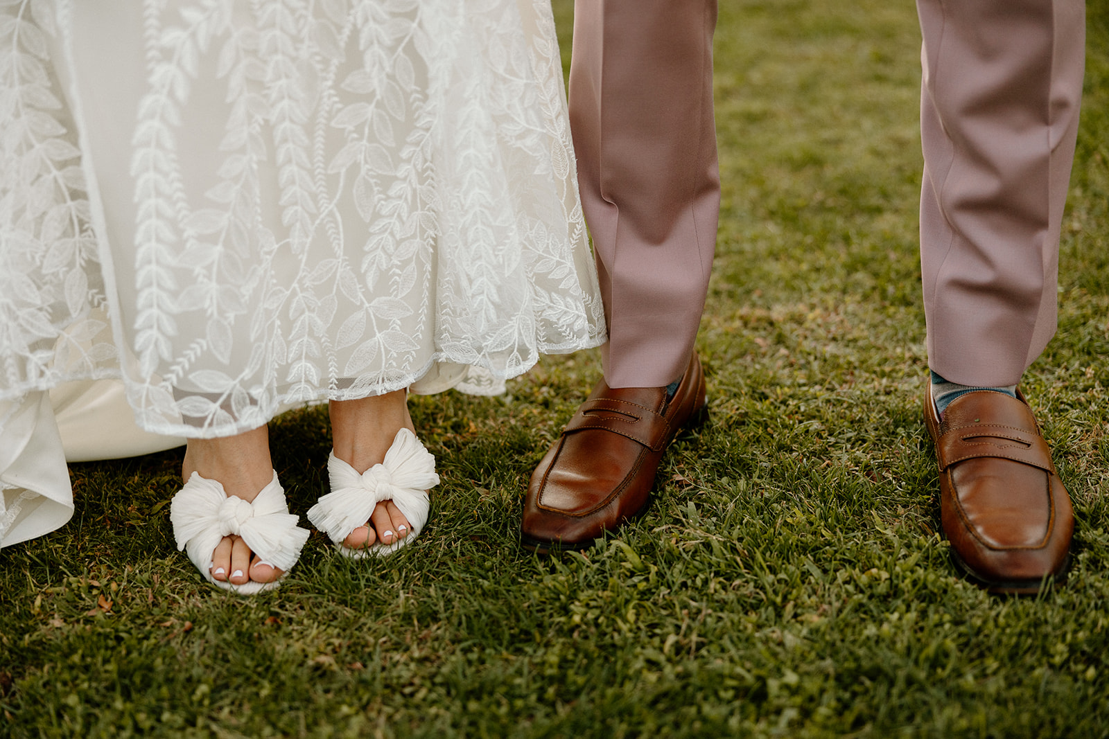 Bride and groom pose with their wedding shoes 