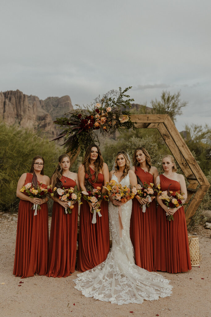 bride poses with her stunning bridesmaids at the stunning lost dutchman state park ceremony site