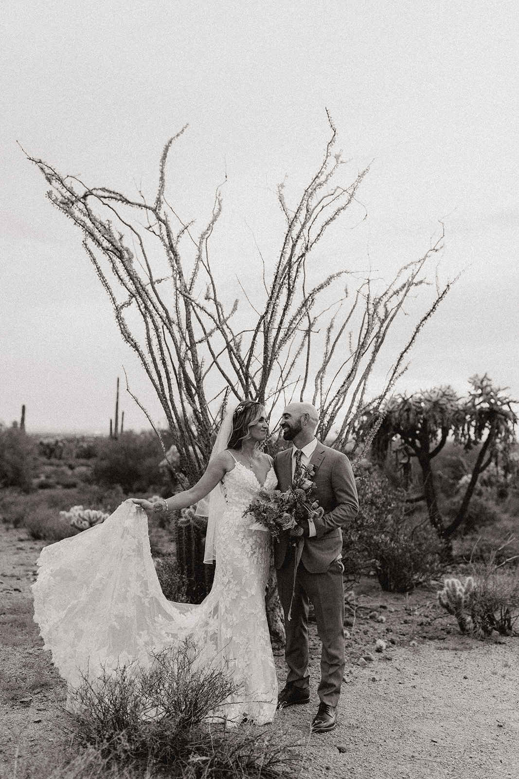 bride and groom pose as the sun goes down after their wedding at lost dutchman state park