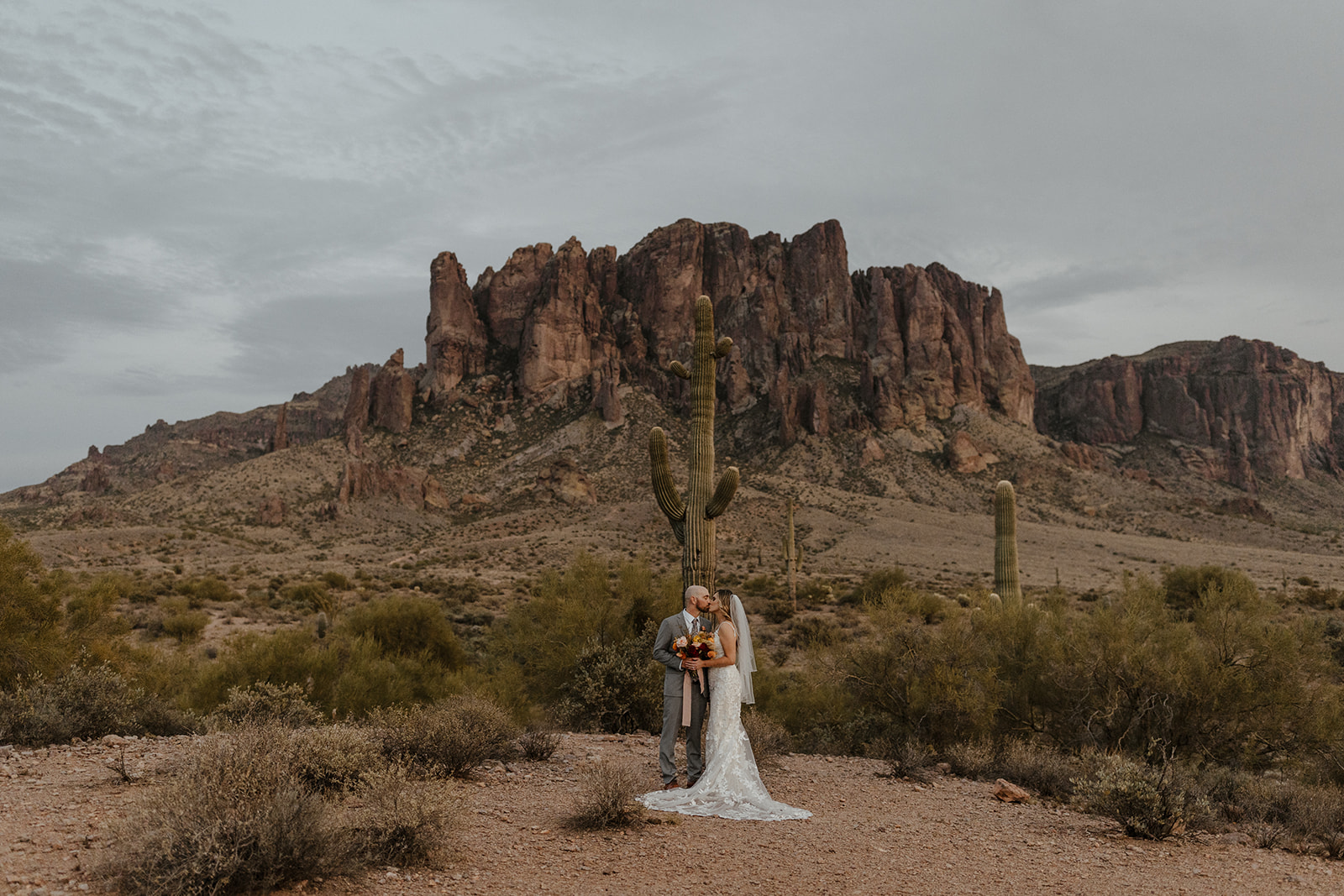 bride and groom pose in the stunning lost dutchman state park after their desert wedding day