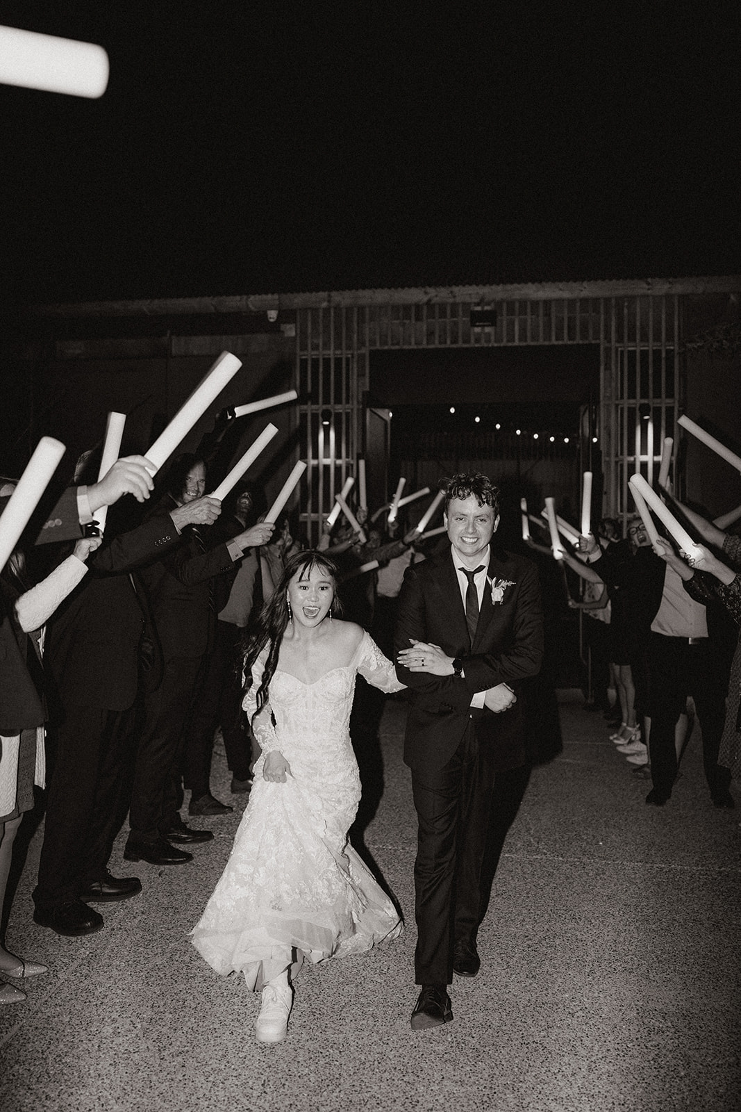 bride and groom exit as their guests celebrate
