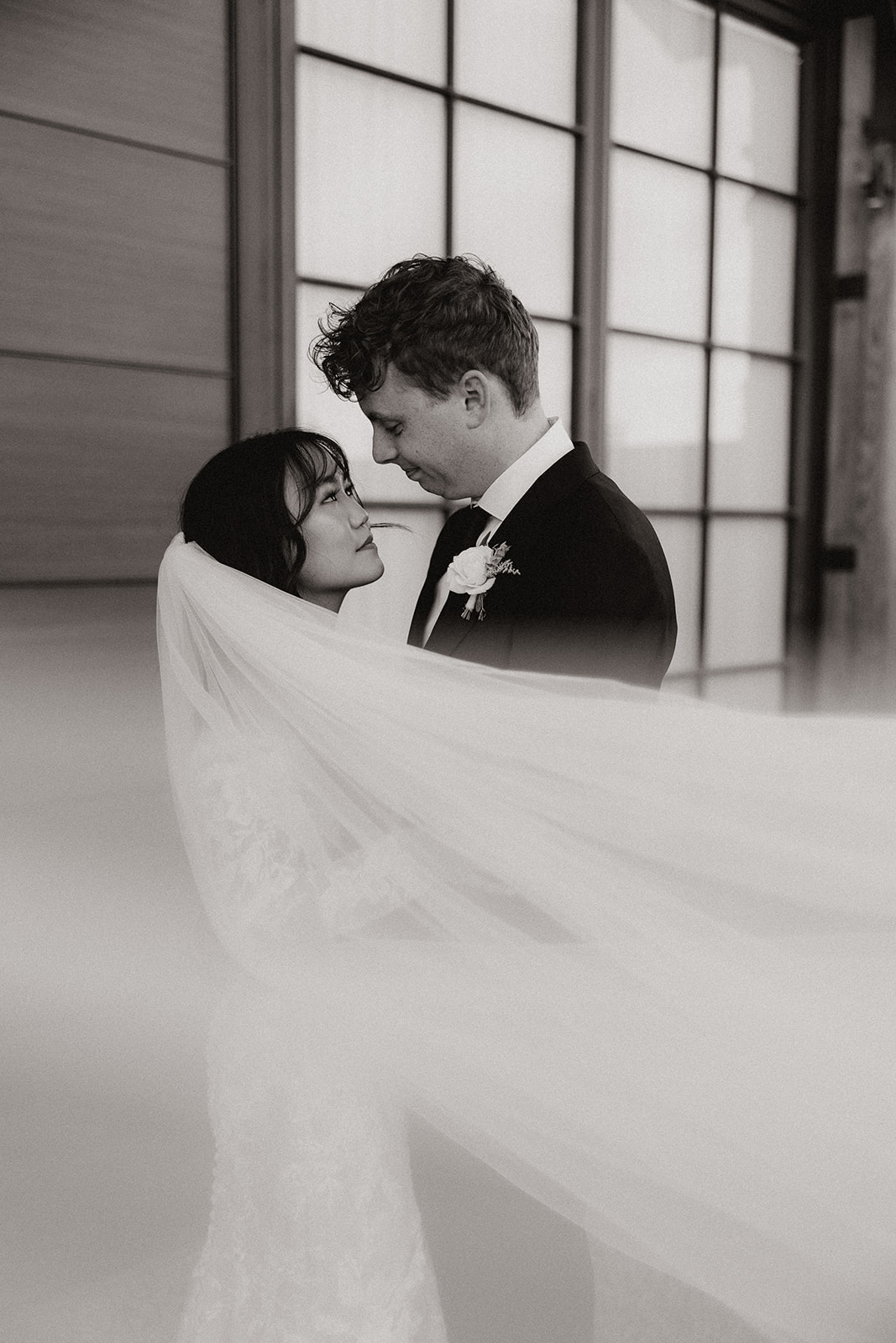 bride and groom share an intimate moment surrounded by her veil 