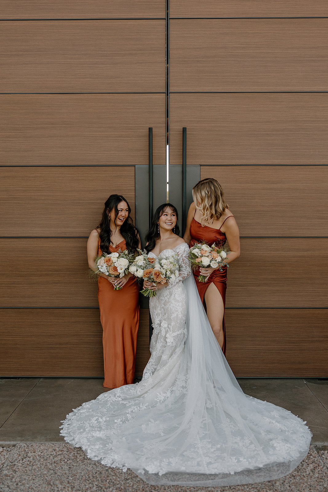 bride poses outside the stunning desert wedding venue with two of her bridesmaid 