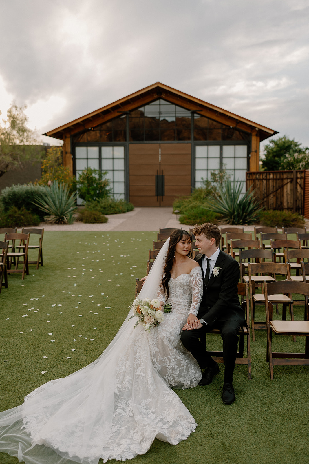 stunning bride and groom pose in front of the boho desert wedding venue the Paseo