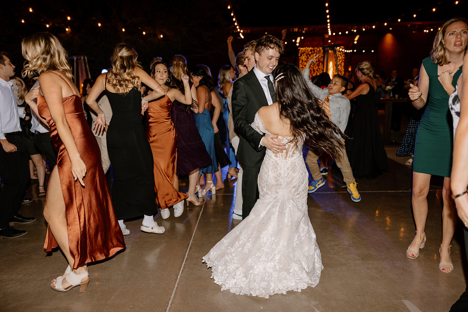bride and groom dance surrounded by their guests