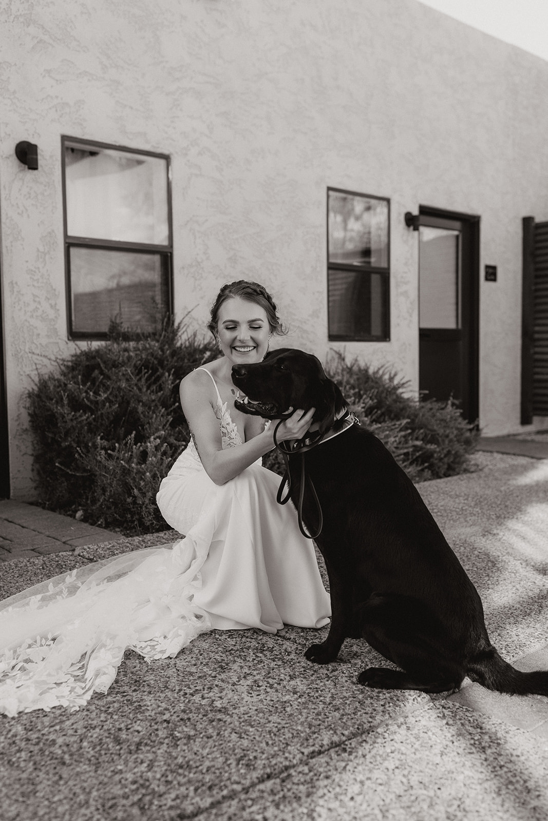 Beautiful bride poses with her loving dog before her stunning AZ desert wedding