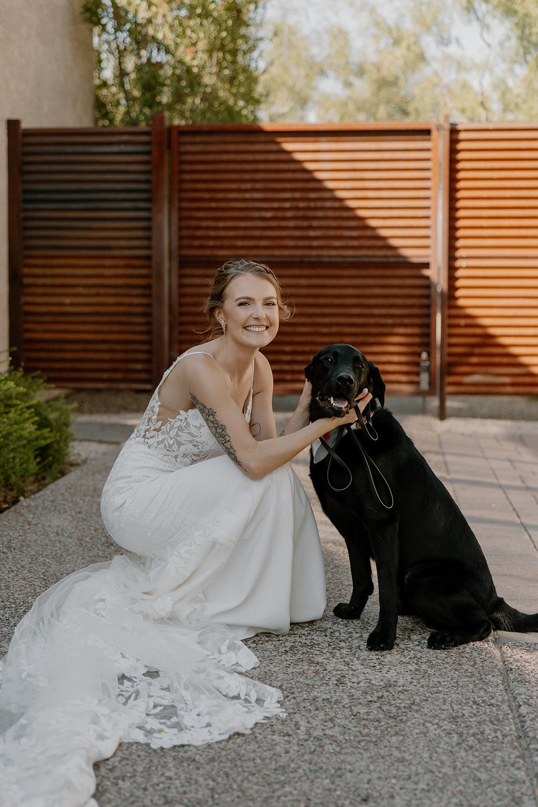 Beautiful bride poses with her loving dog before her stunning AZ desert wedding