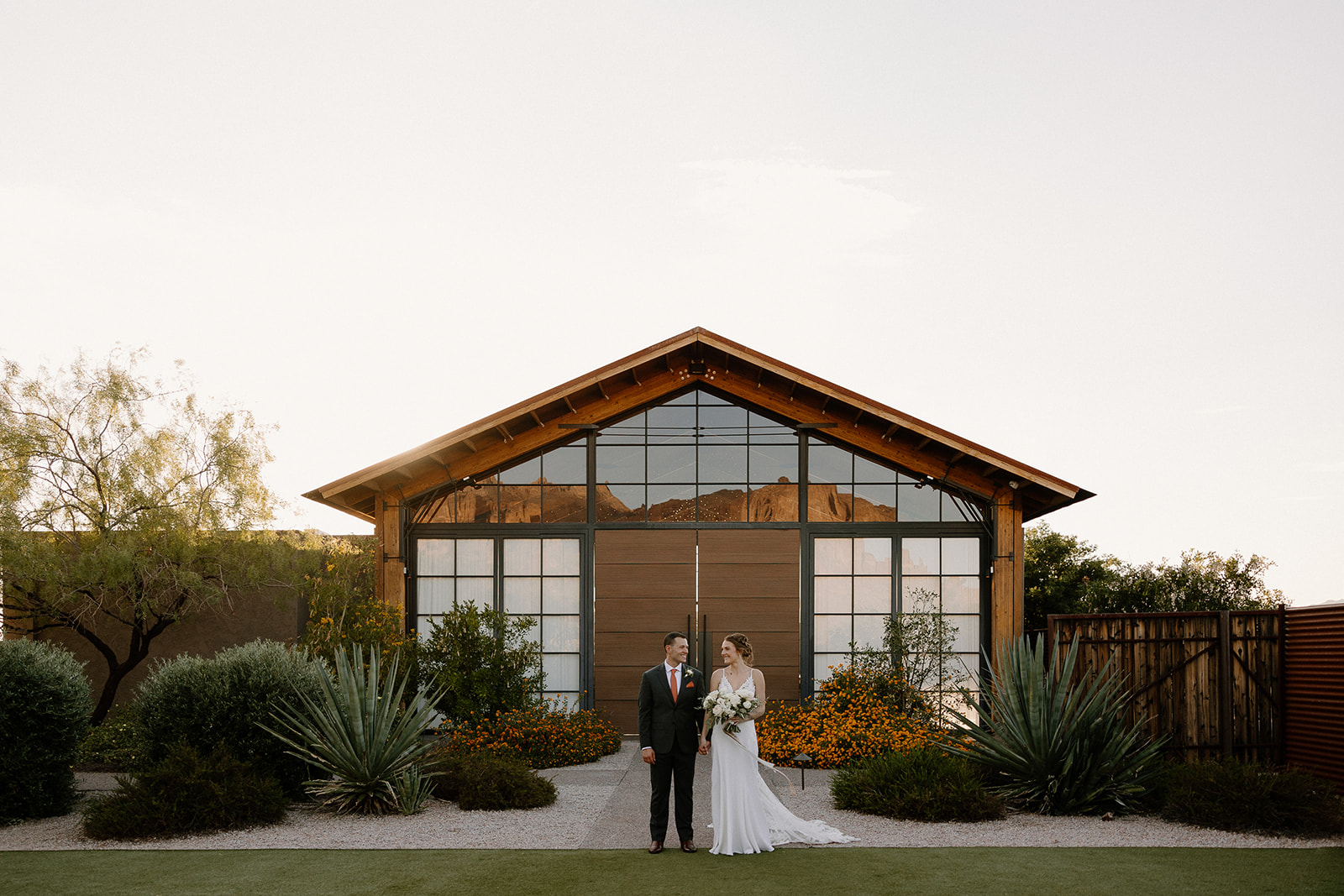 Stunning bride and groom. pose with the dreamy AZ desert wedding venue in the background