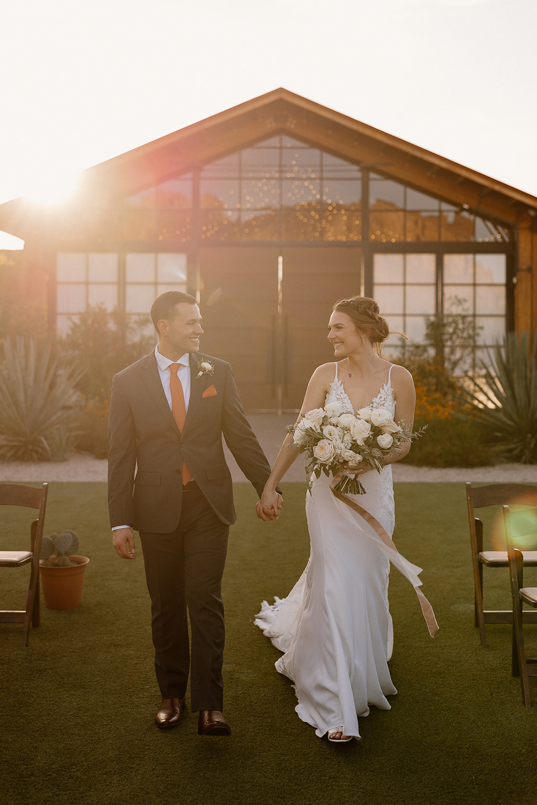 bride and groom pose with the stunning Arizona desert wedding venue in the background