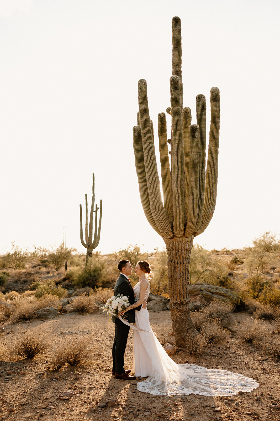 Stunning bride and groom pose in the desert after their stunning Arizona wedding
