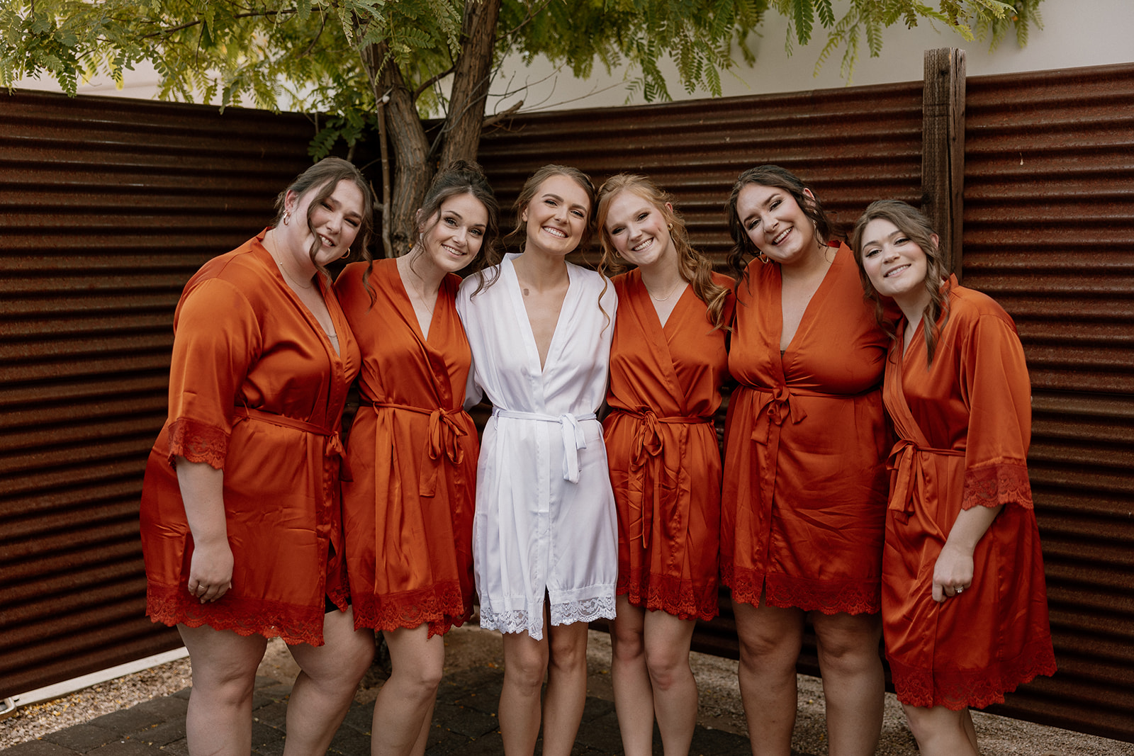 Beautiful bride poses with her bridesmaids before her dreamy AZ desert wedding 