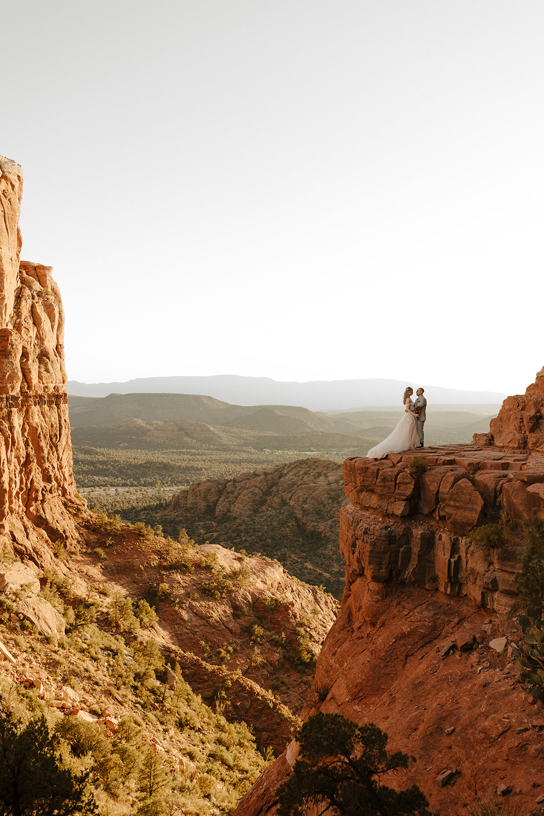 stunning bride and groom pose together on cathedral rock in arizona.