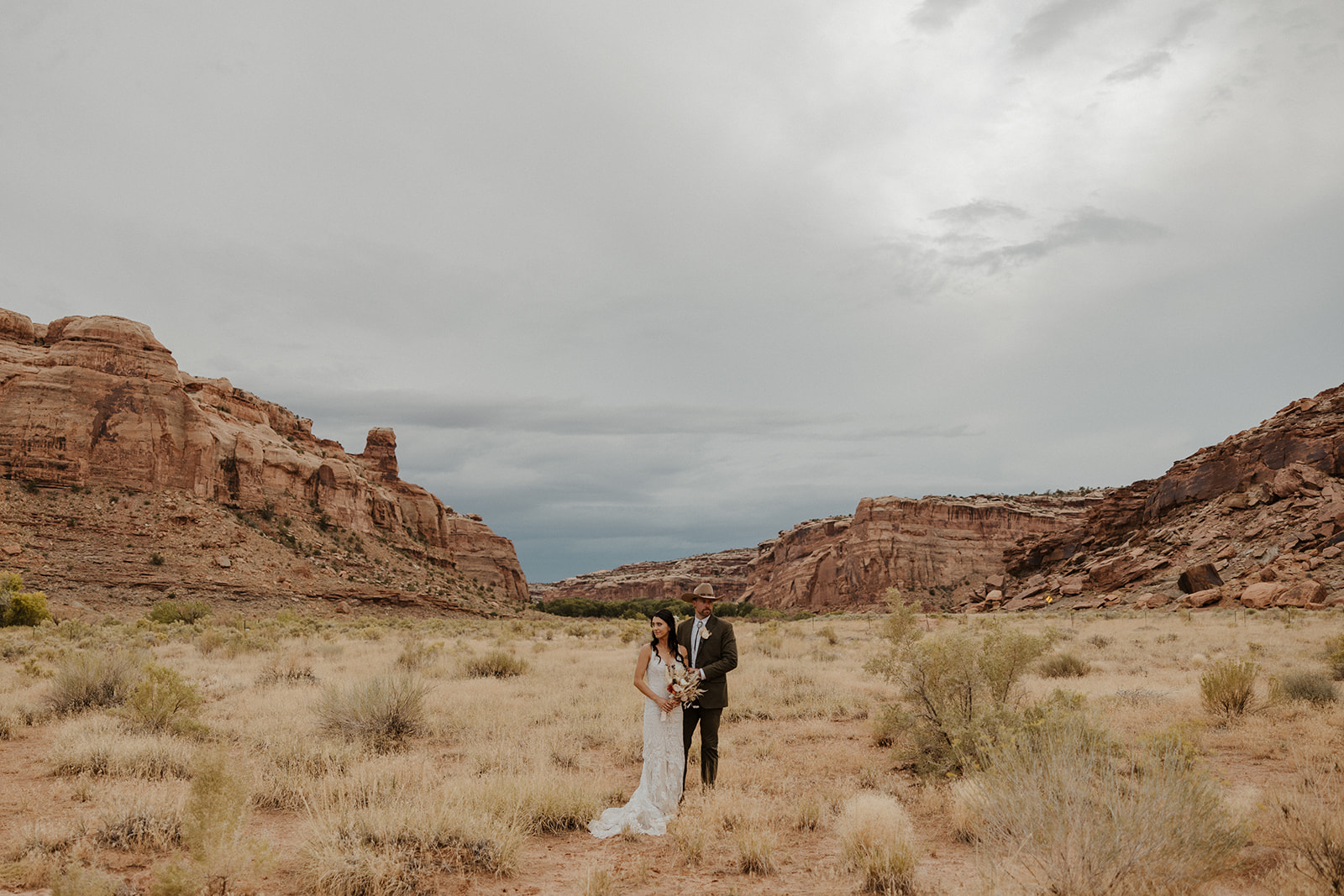 bride and groom pose with the stunning Arizona mountains in the background