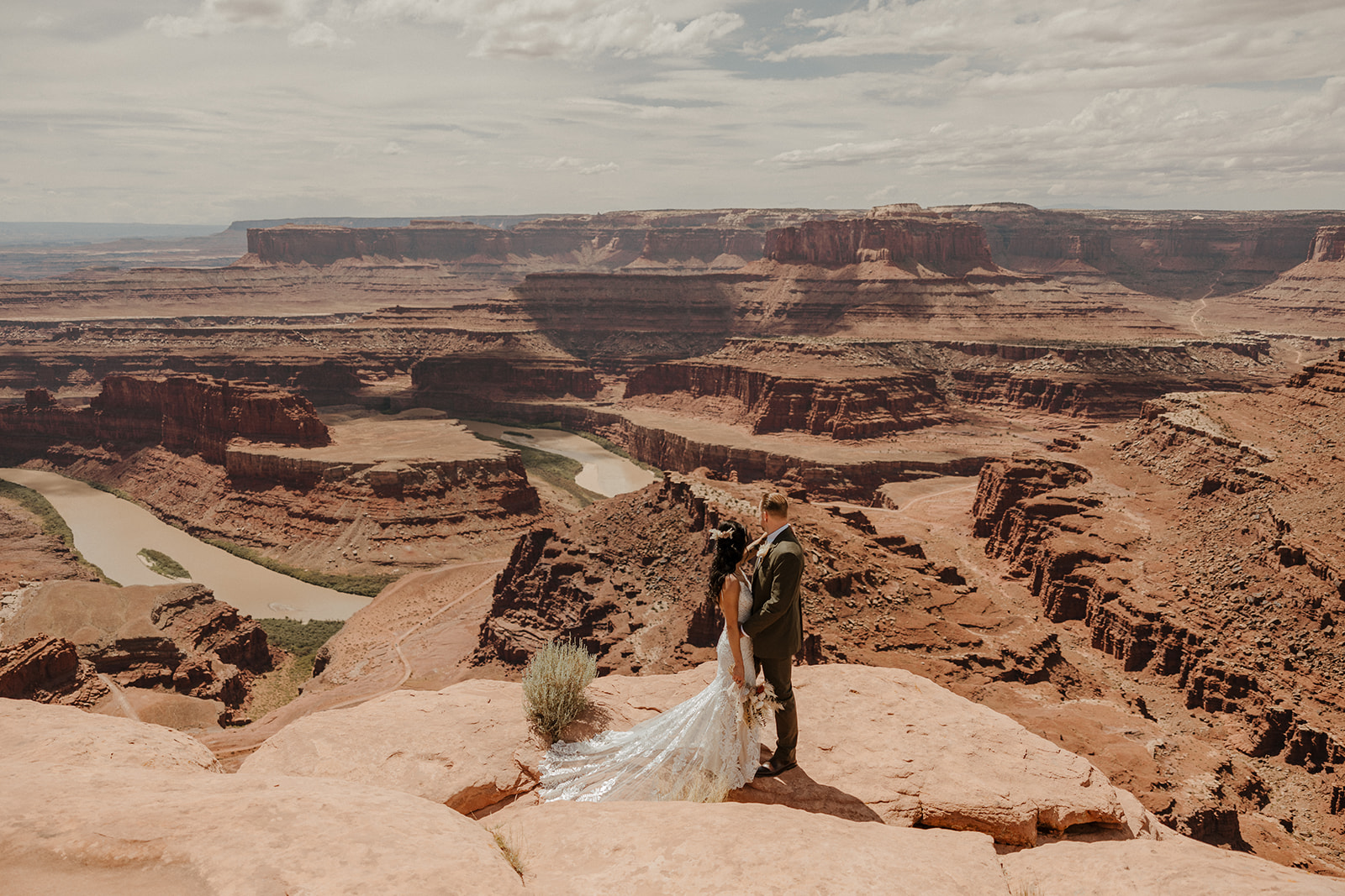 bride and groom pose with the stunning canyon in the background