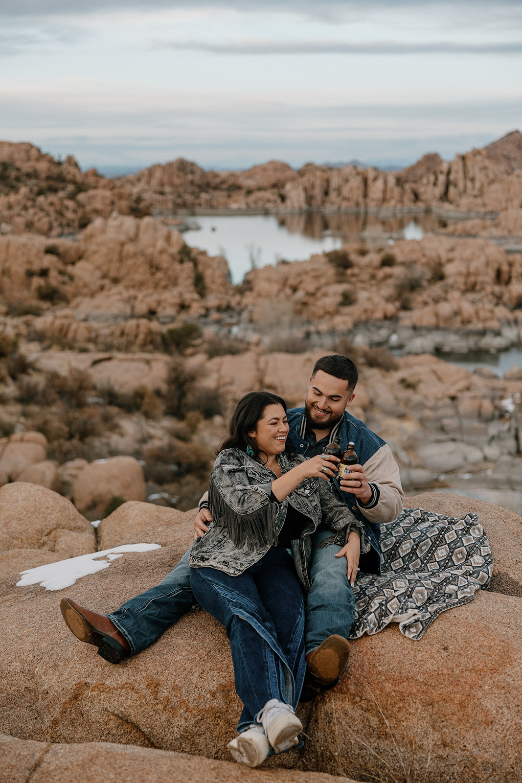 couple toast their beers with the gorgeous Arizona landscape in the background 