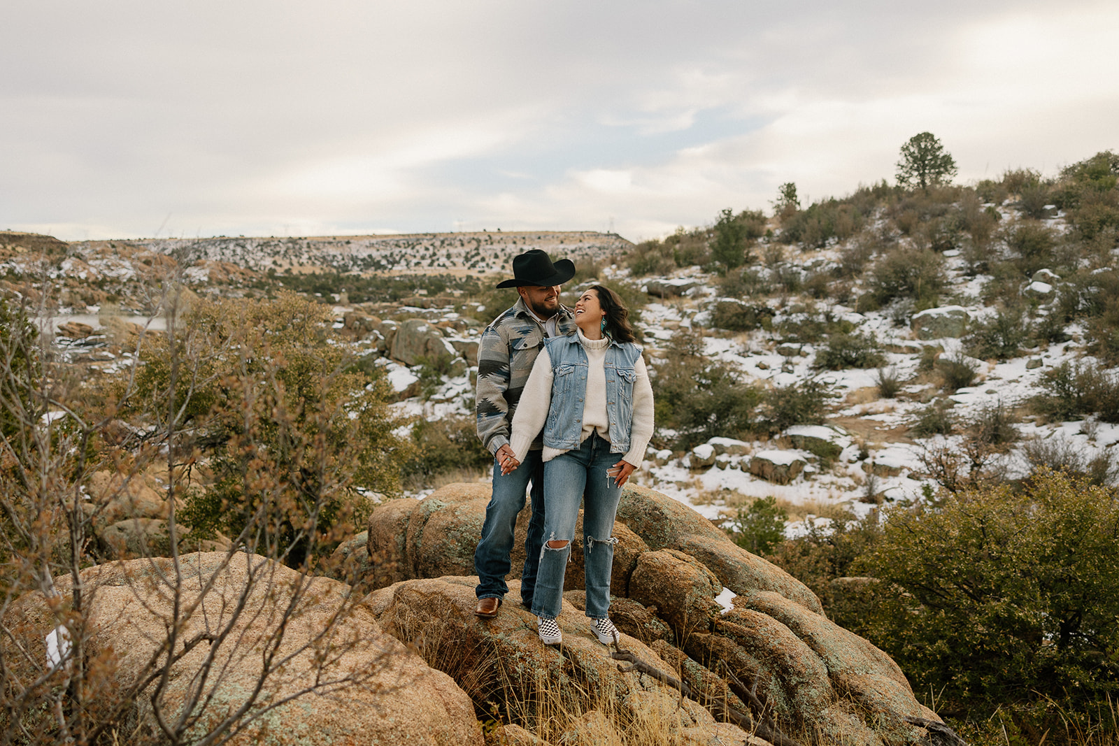 Beautiful couple poses with snow in the background during their dreamy Arizona lake engagement