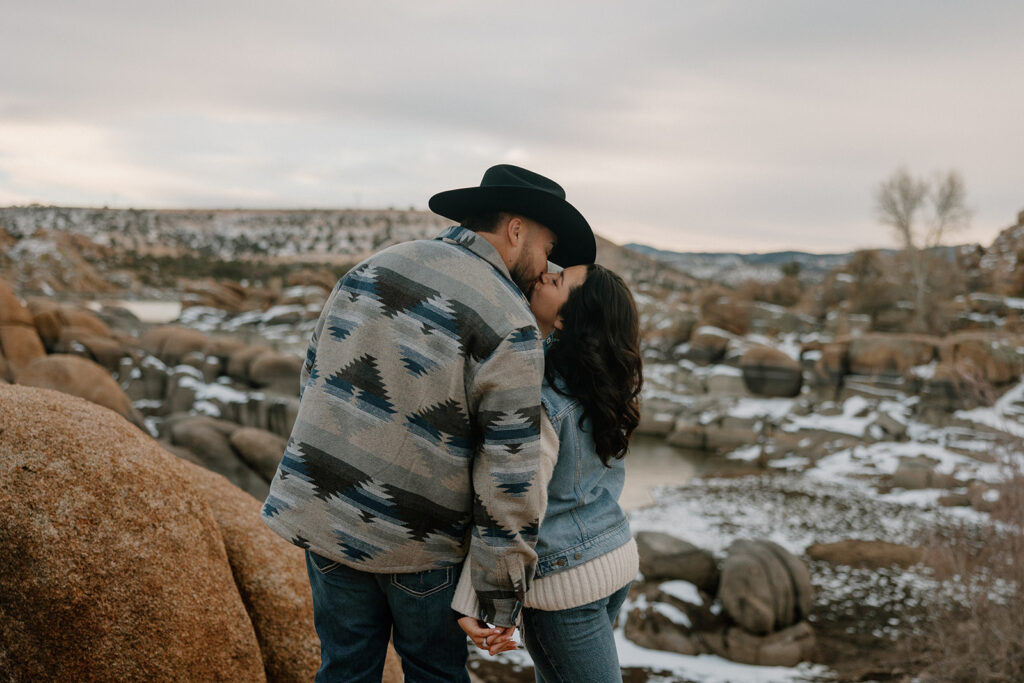 Beautiful couple poses with snow in the background during their dreamy Arizona lake engagement