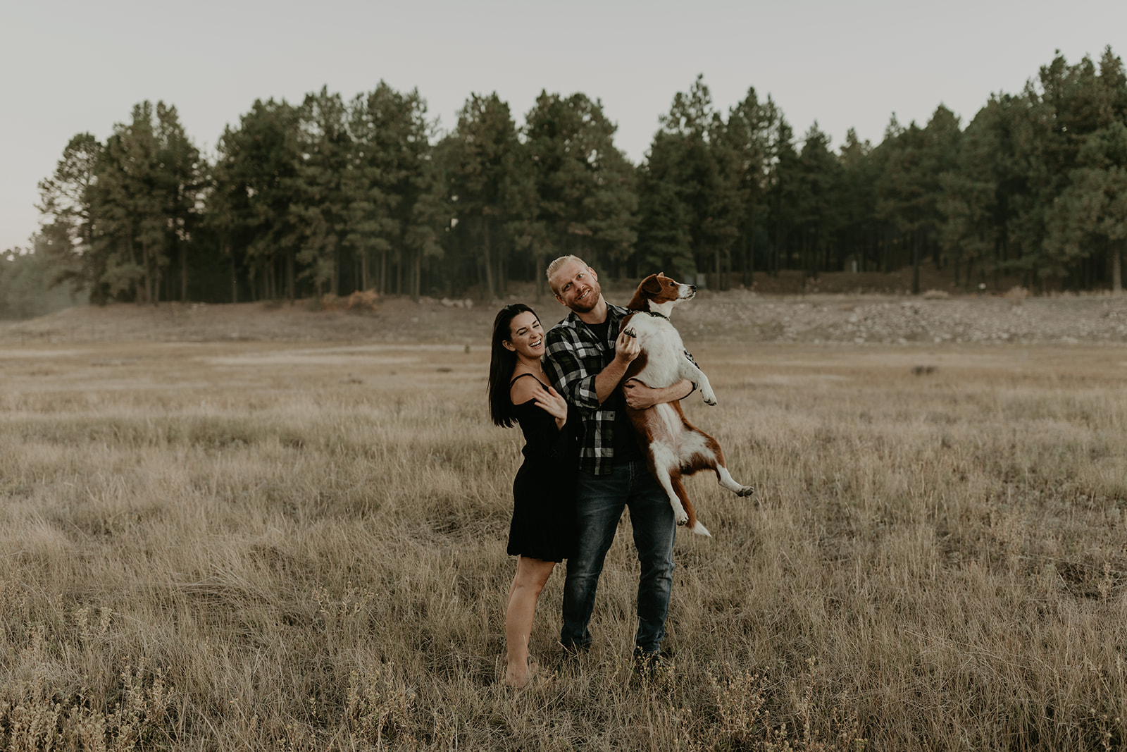 couple pose their dog in a field outside their Arizona home