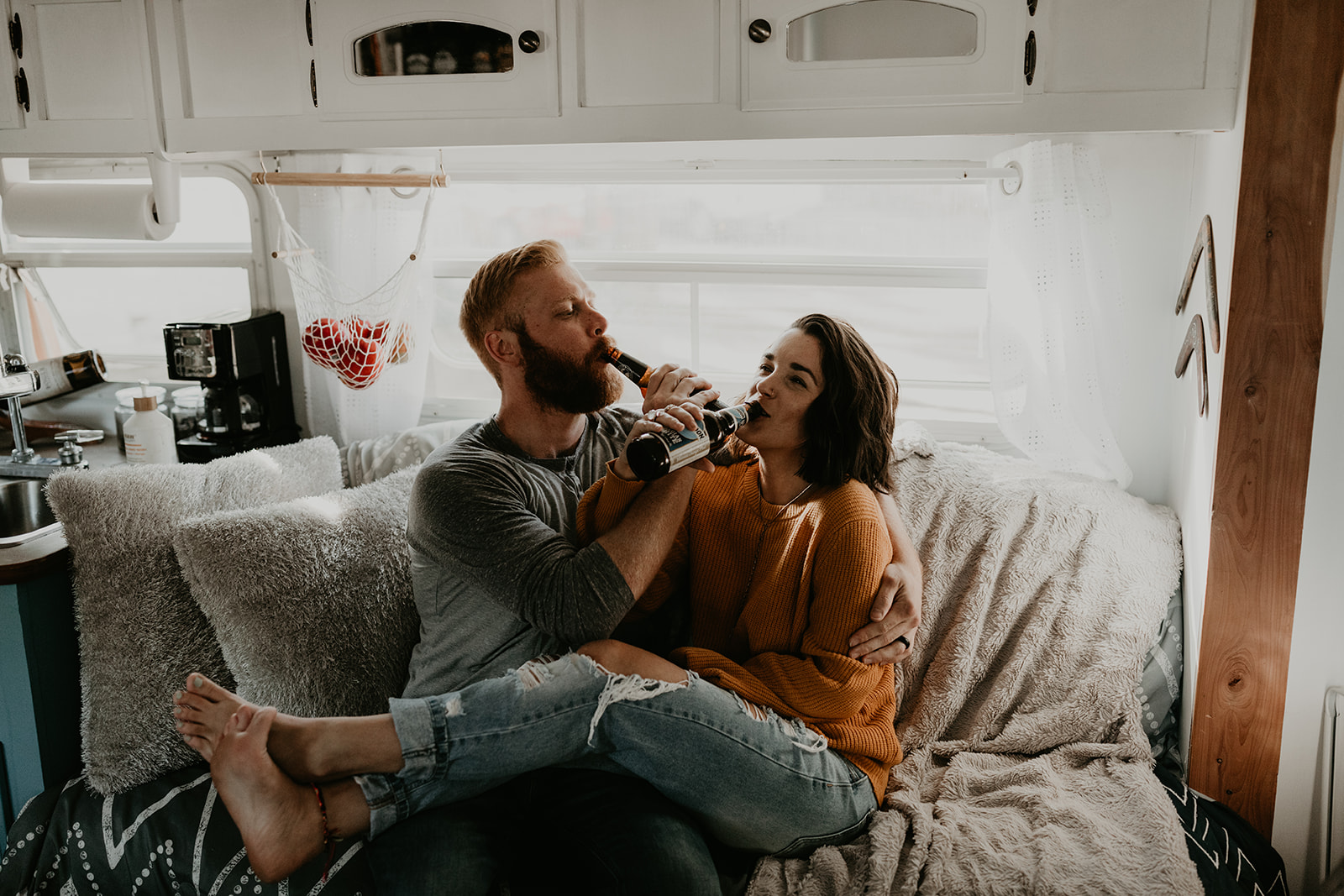 couple shares a moment and a beer during their in home couple photoshoot