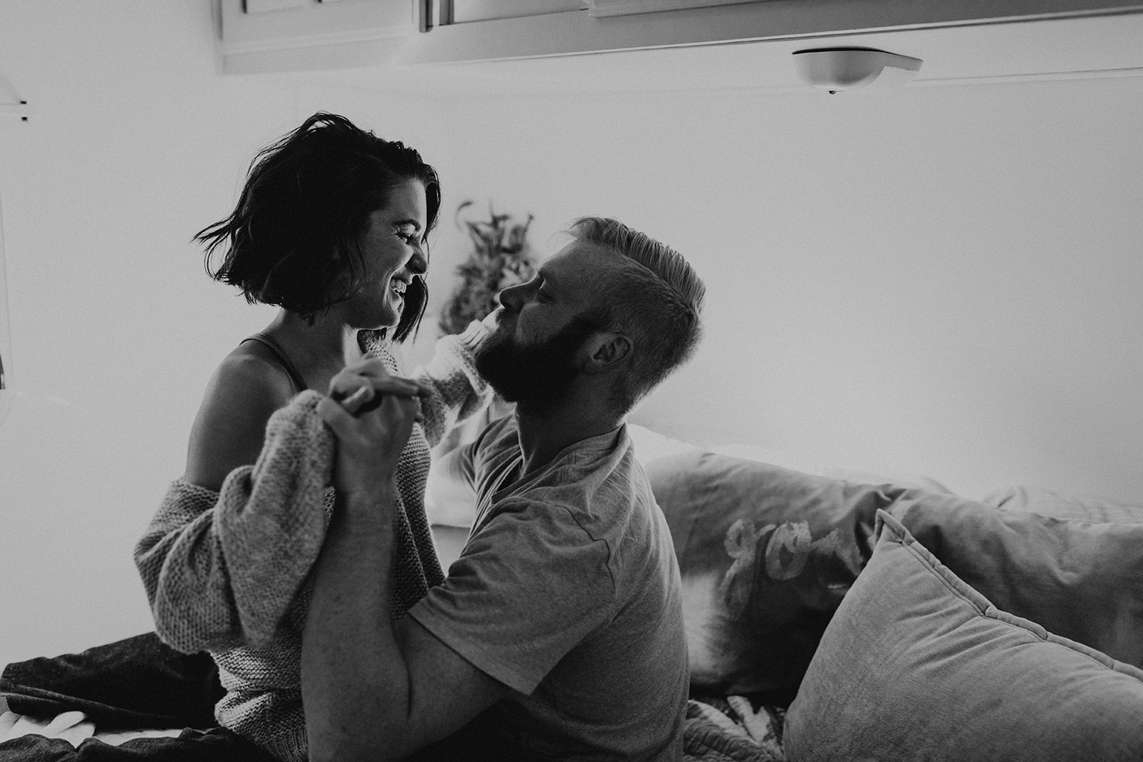 couple pose on the bed together during their couple photoshoot ideas at home