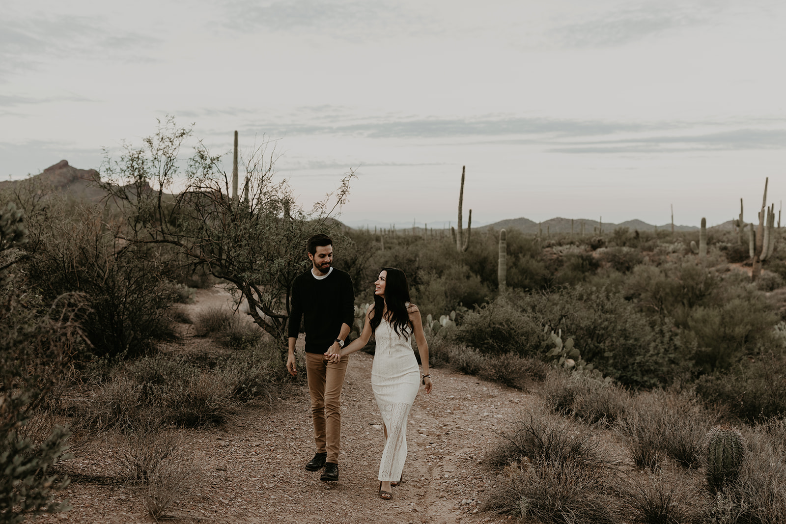 stunning couple pose walk together in the Arizona desert during their hiking engagement photos