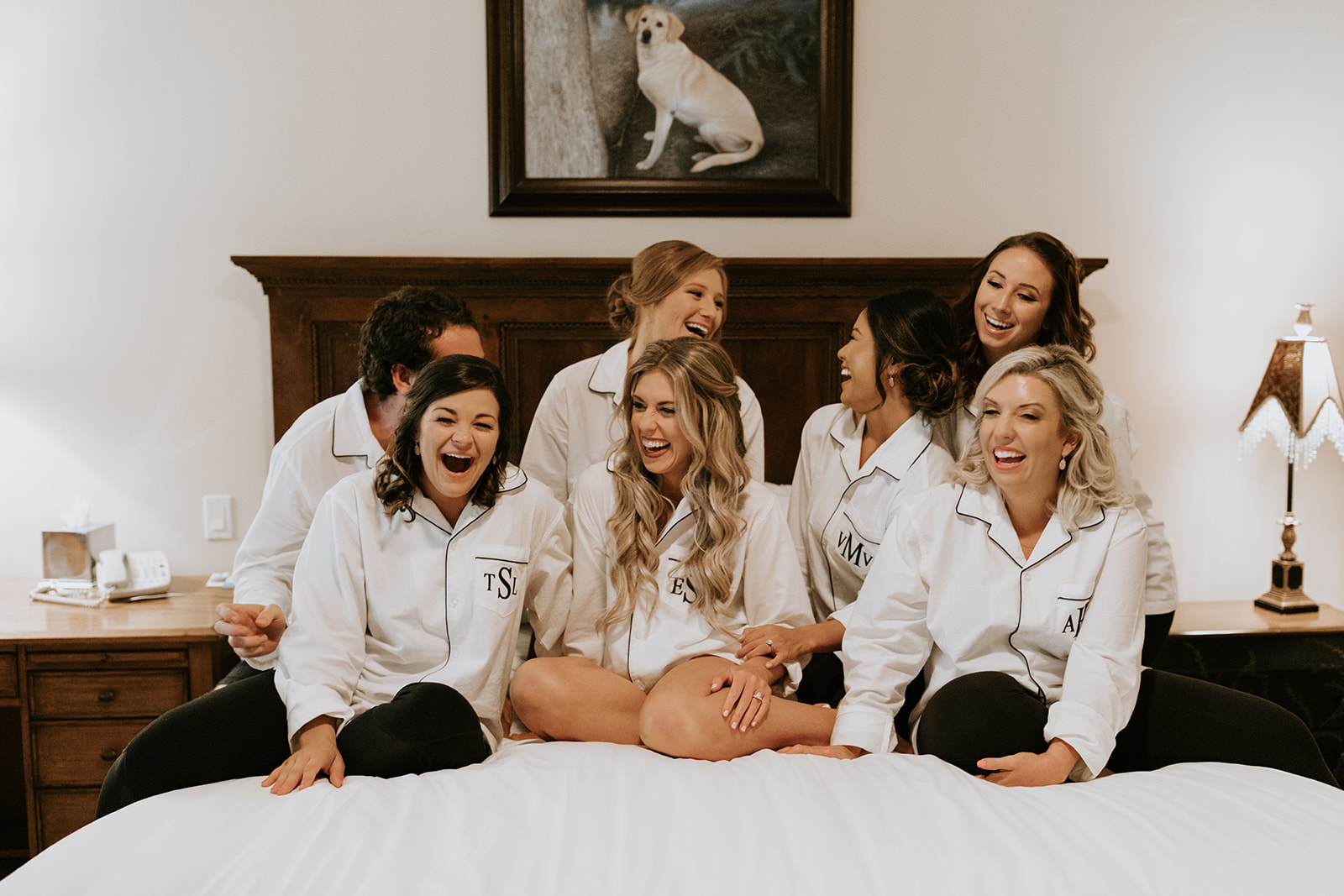 bride sits and laughs with her bridal party as they prepare for her dreamy wedding day