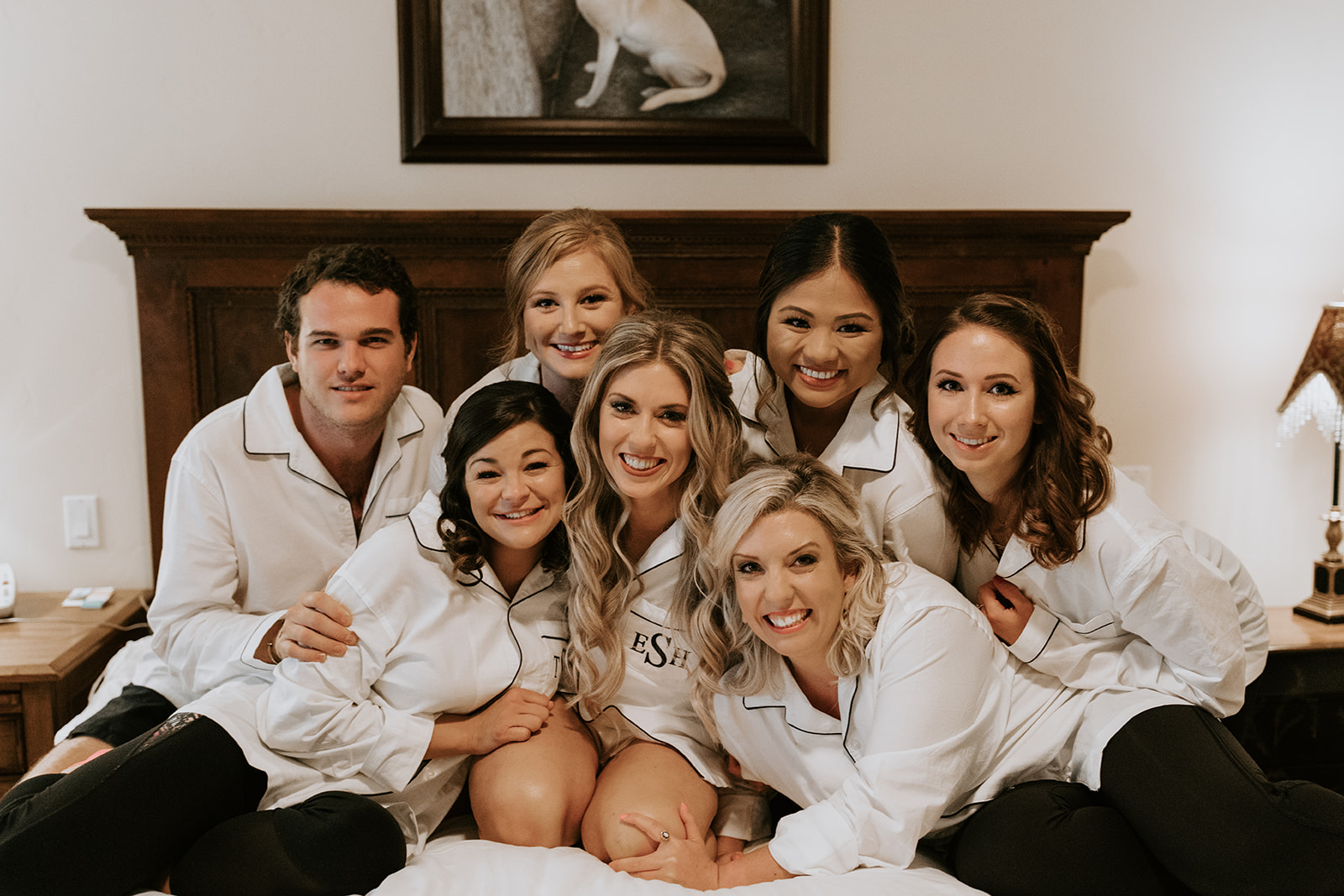 bride sits and laughs with her bridal party as they prepare for her dreamy wedding day