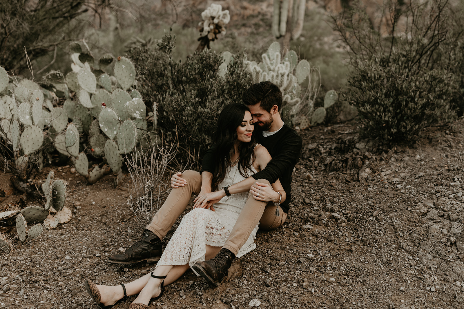 stunning couple sit in the Arizona desert together during their dreamy hiking engagement photos