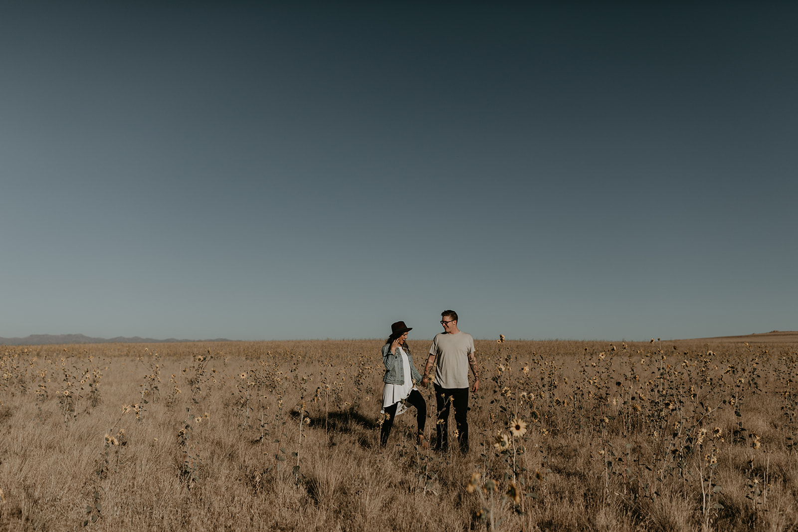 couple pose in a sunflower field in Utah during the fall 