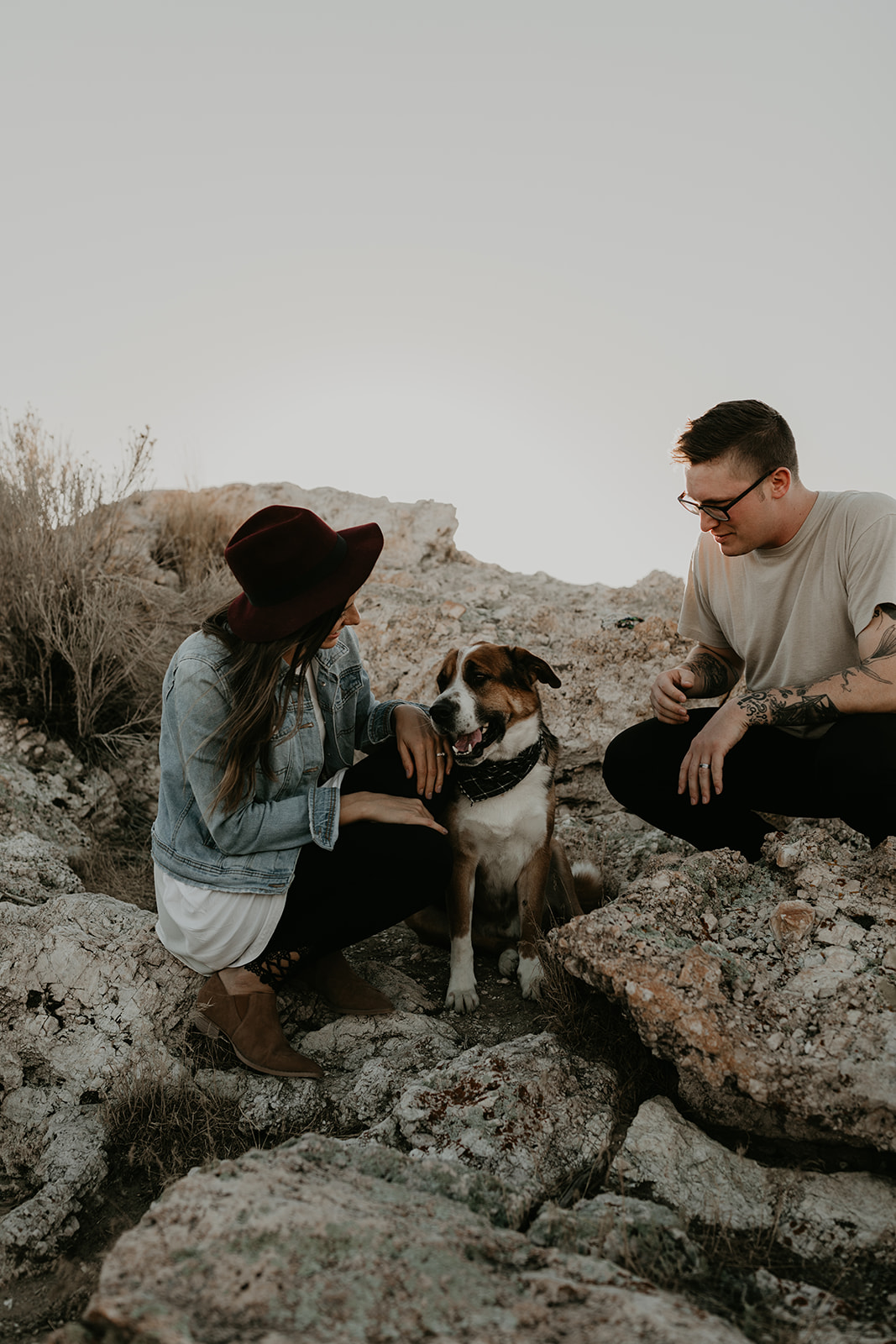 couple pose together with their dog on rocks in the beautiful Utah nature during their Engagement photos in Utah