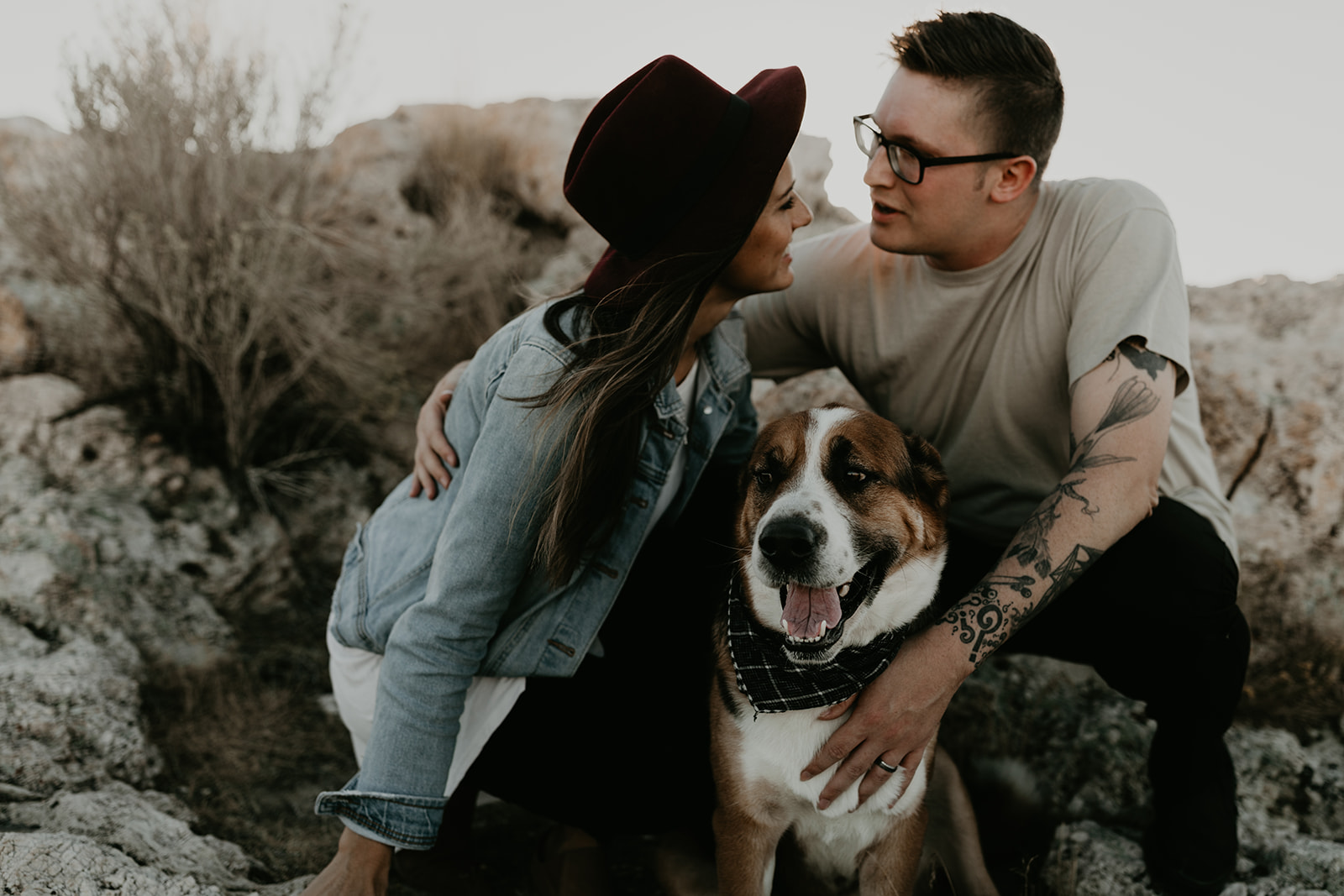 couple pose together with their dog on rocks in the beautiful Utah nature during their Engagement photos in Utah